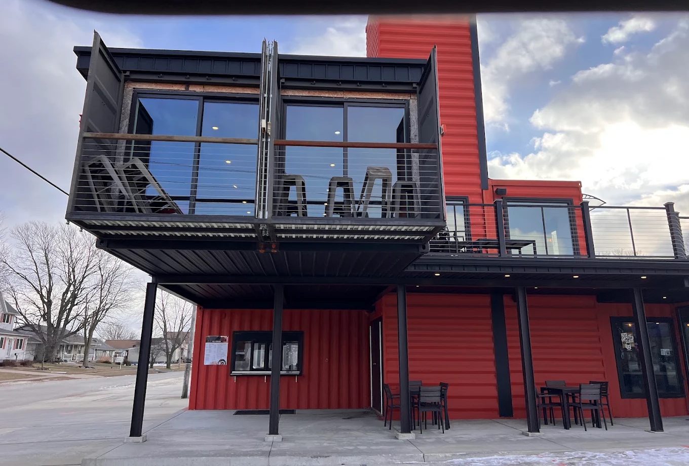 COFFEE CAN's red shipping-container building, with the drive-thru window and menu board below the cantilevered upper container